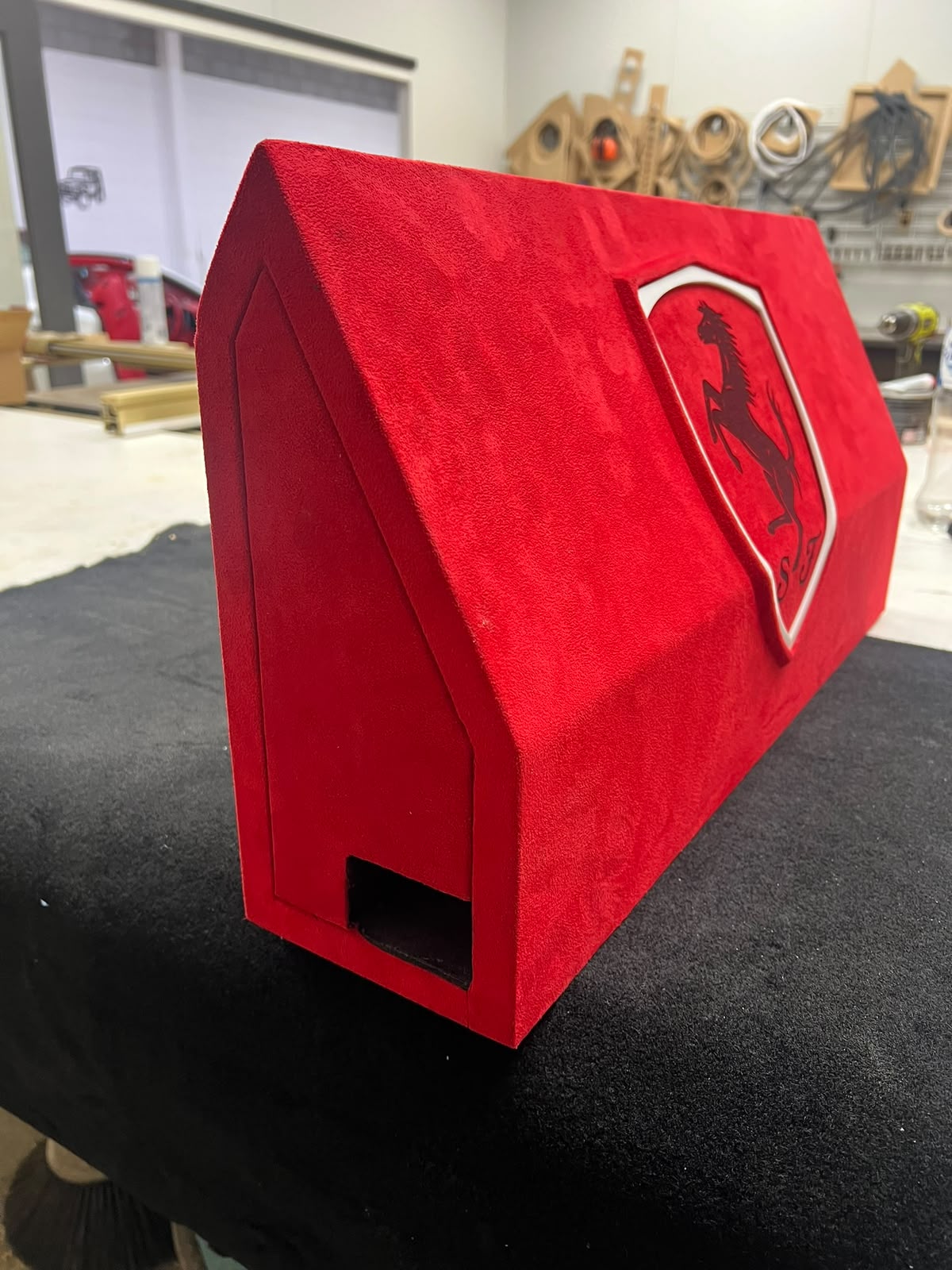 Red suede subwoofer enclosure trimmed to match a Ferrari interior